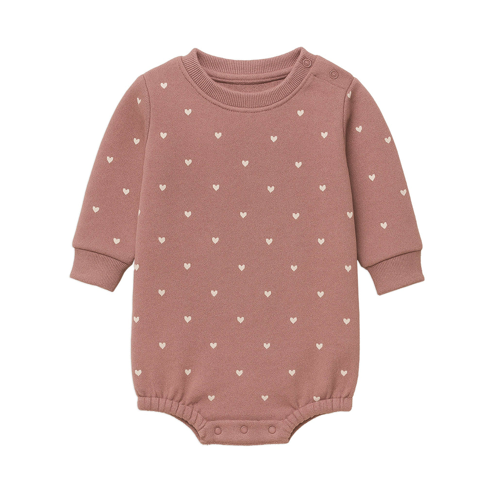 Pink baby romper with heart patterns on a white background